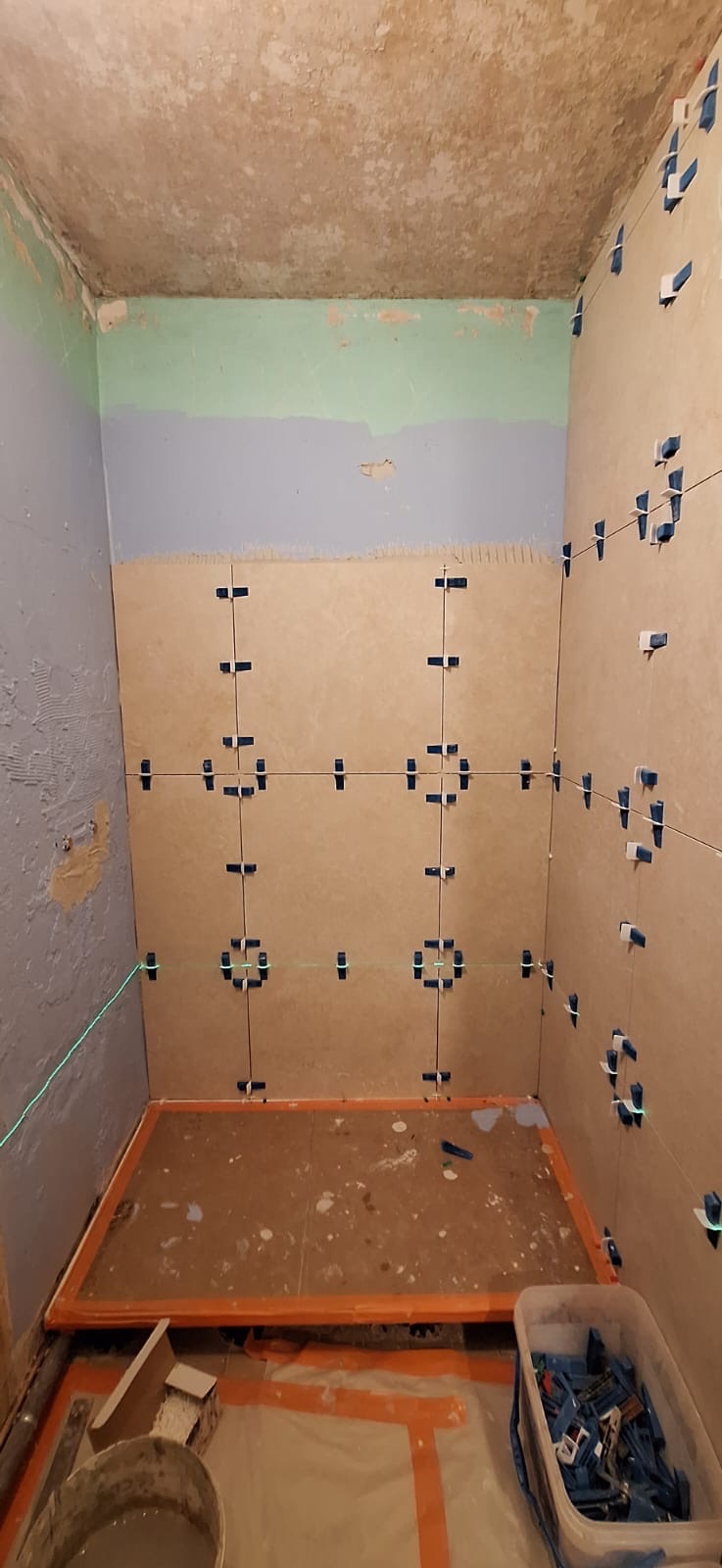 Pose du carrelage et du receveur de douche pendant une rénovation